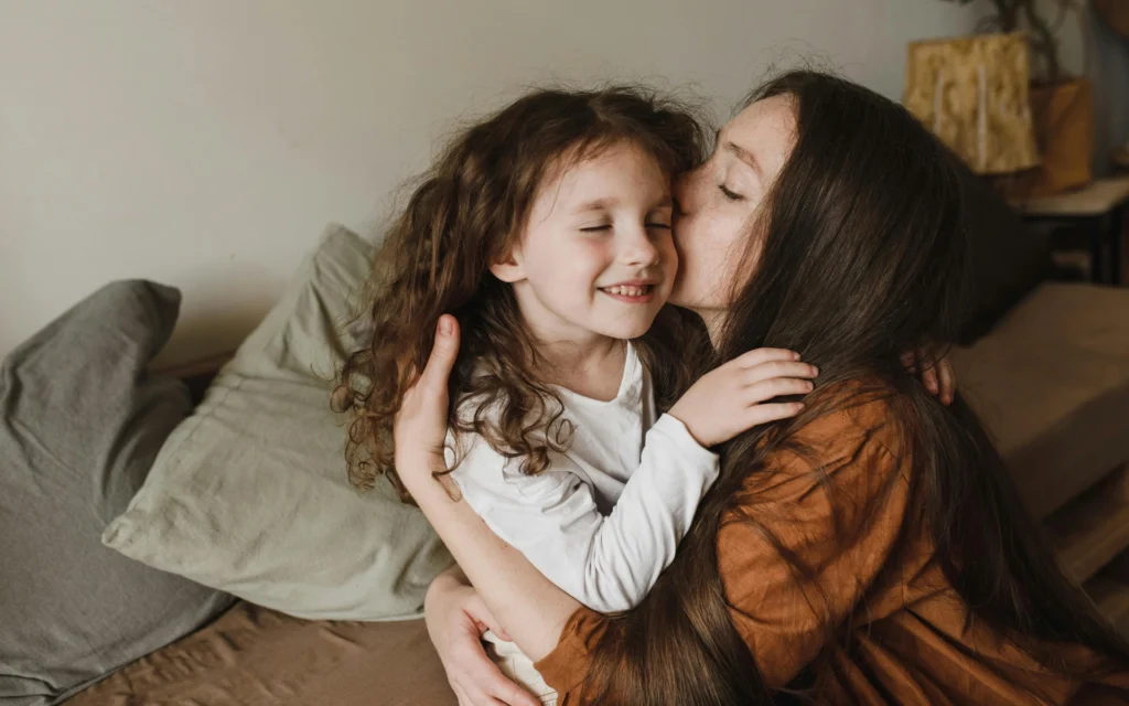 Eine Mutter umarmt ihr Kind, gerade für Kinder ist eine Berührung essentiell für ein gesundes Heranwachsen.