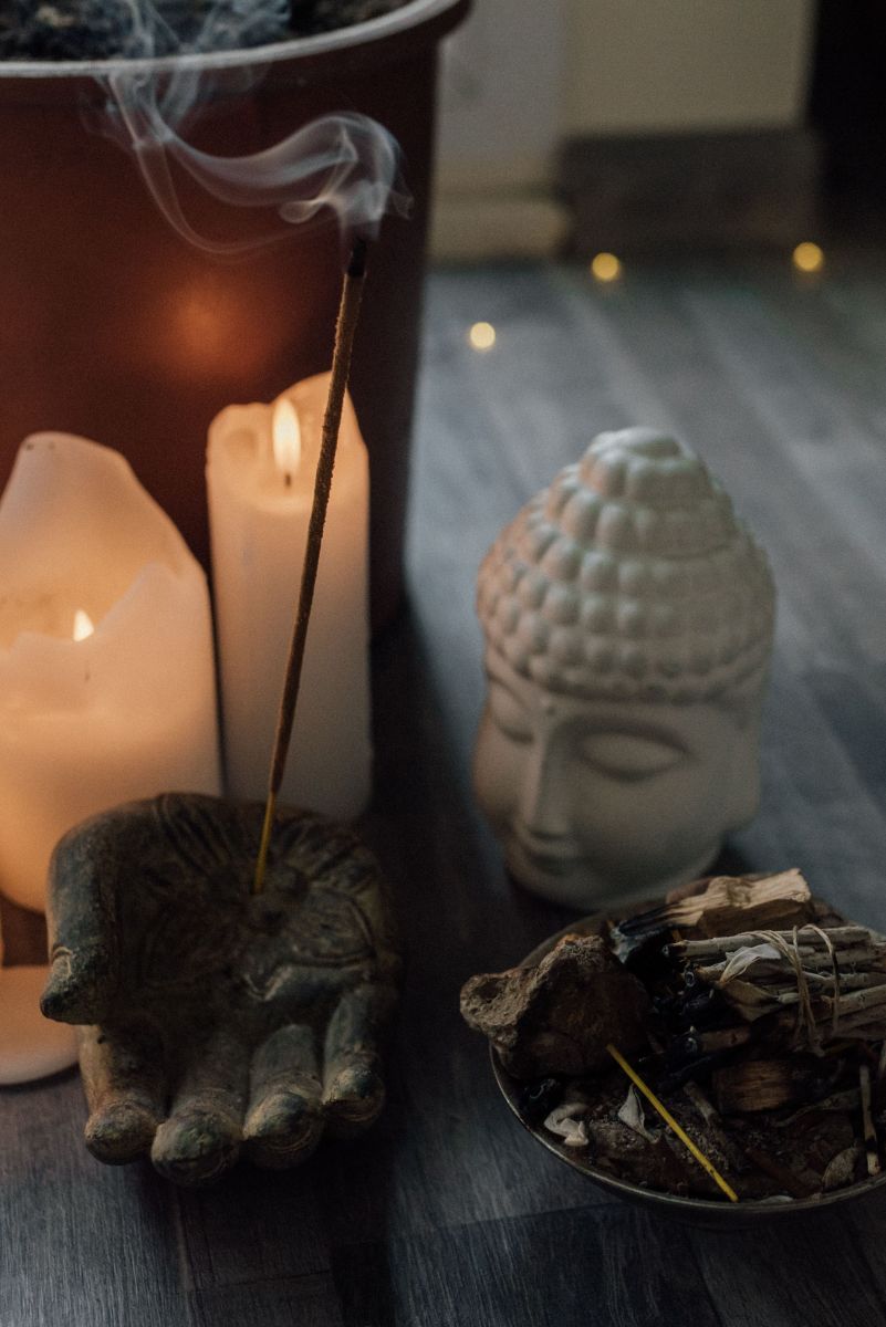 Kerzen, Räucherwerk und Buddha-Figur als Symbol für achtsame Rituale im Alltag
